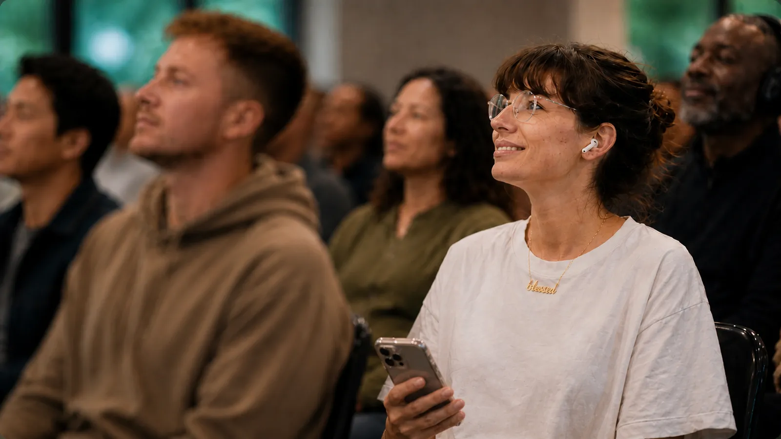 Audience at a live event listening to a live translation via AirPods and headphones